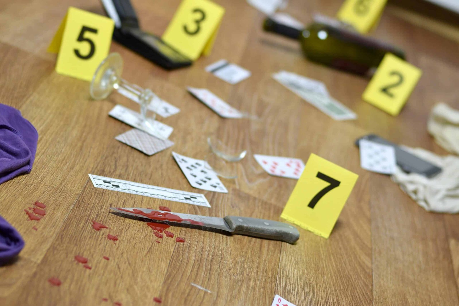 Crime scene investigation - numbering of evidences after the murder in the apartment. A lot of playing cards, wallet and bottle of wine as evidence